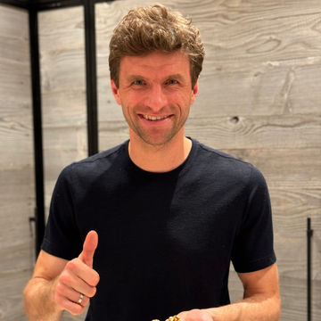 Thomas Müller schaut lächelnd in die Kamera mit einem Daumen hoch.
